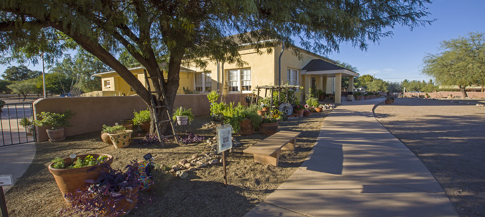 A view of the main Presidio building, with the plants and flowers lining the sidewalk leading to it.