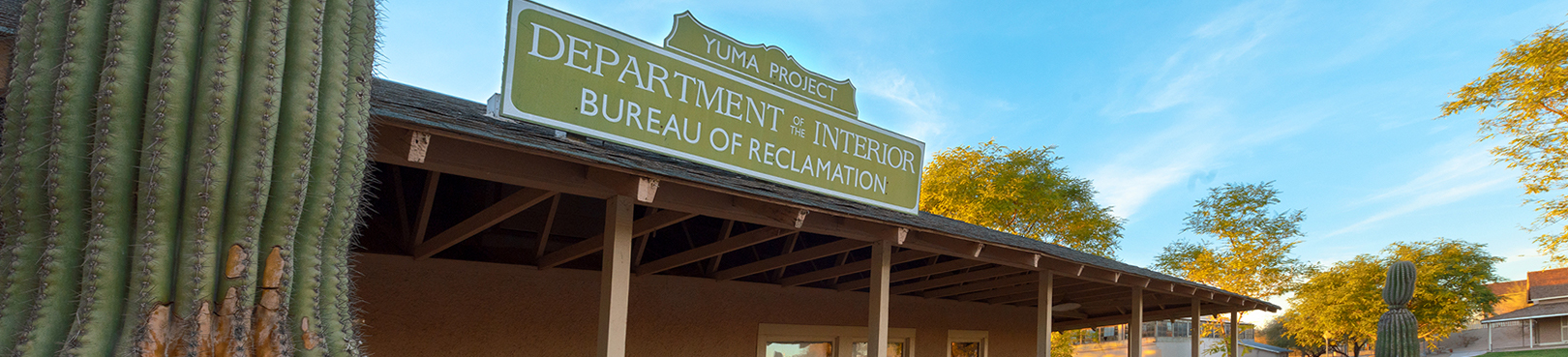 A historic looking department of Interior sign for the Yuma office of the Bureau of Reclamation sits on the roof of the ranger station.