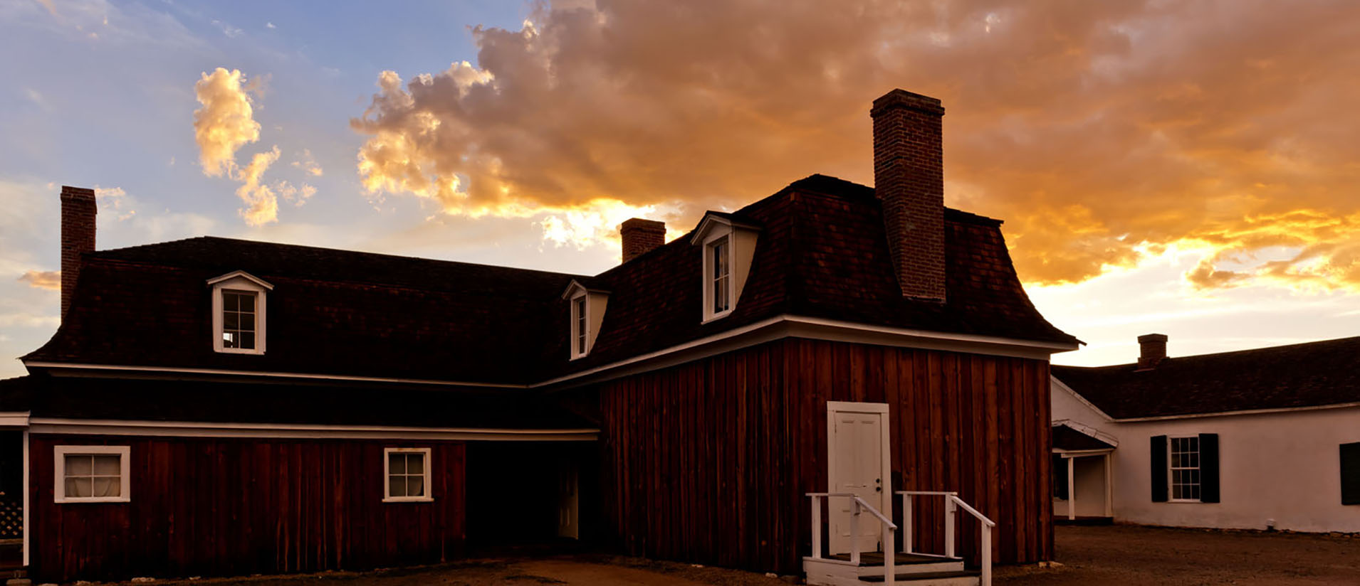 The sun sets behind one of the main buildings at Fort Verde State Historic Park