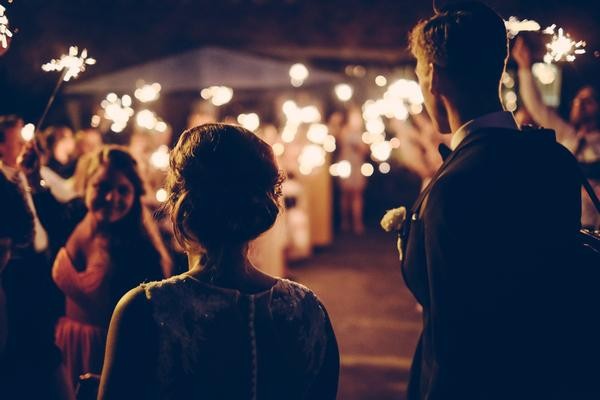 A bride and groom step into the reception area at the park