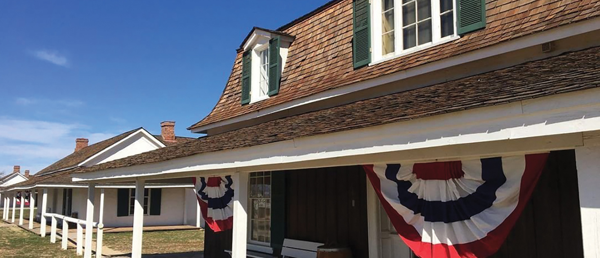 A man rides a bicycle past a gray RV camper at Dead Horse Ranch State Park