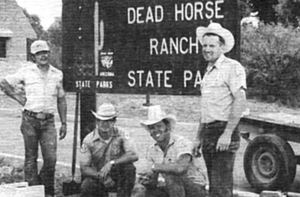 Park staff pose for a picture around the park sign
