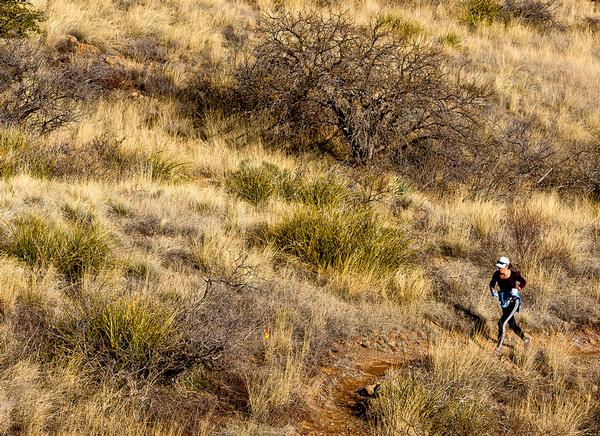 WOman jogging on a high desert trail at Oracle State Park