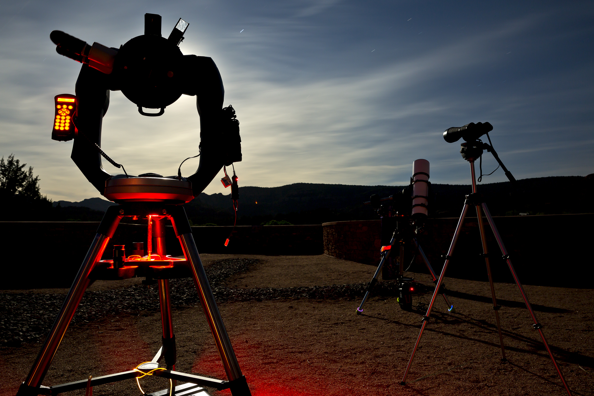 Telescopes set up under the night sky.